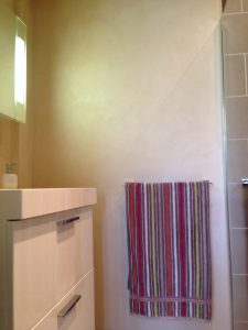 APPLICATION D'ENDUIT EFFET SOIE SUR LES MURS D'UNE SALLE D'EAU AVEC VERNIS PROTECTEUR EN FINITION POUR PROTEGER DES EVENTUELLES PROJECTIONS D'EAU